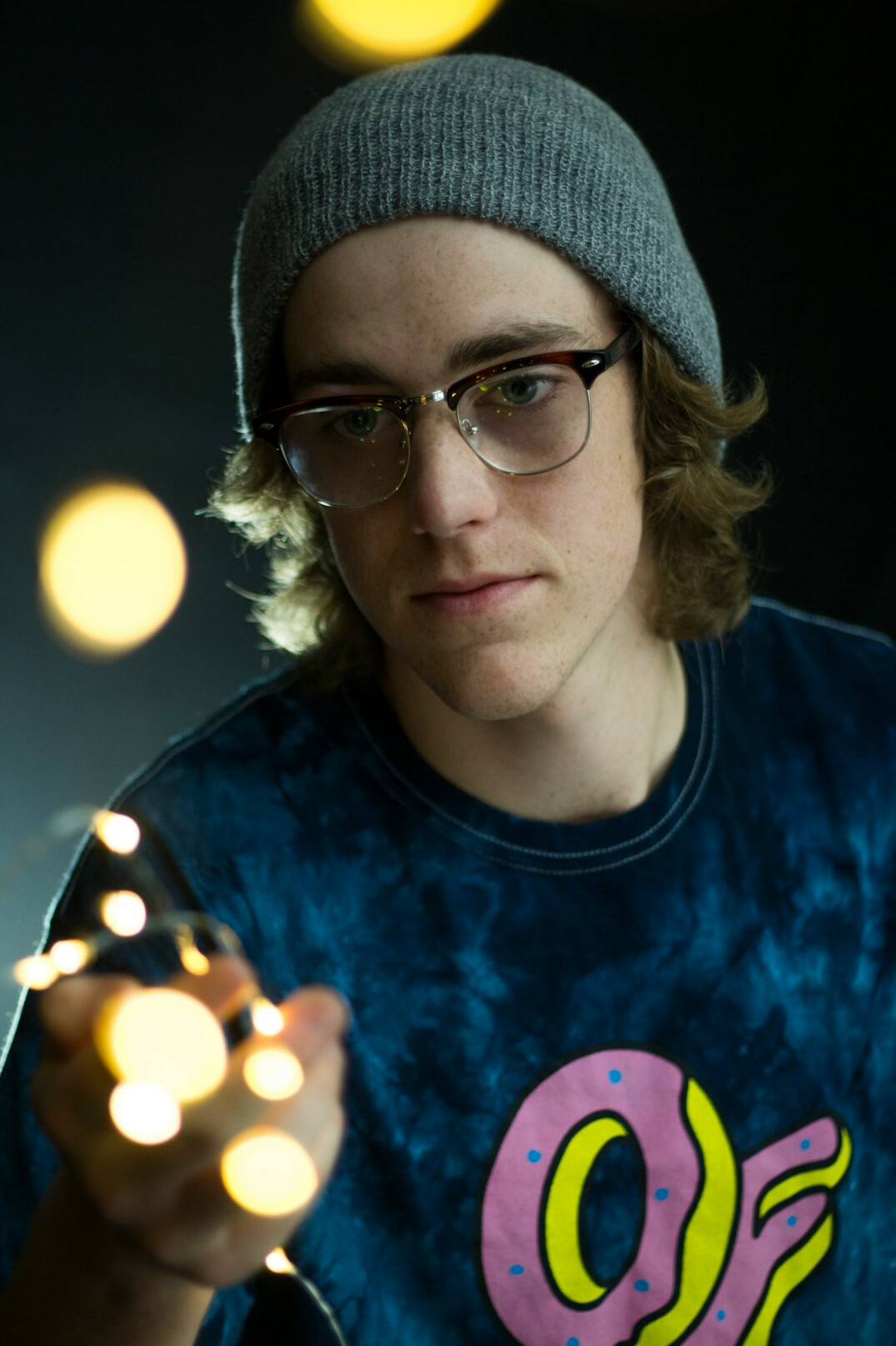 Studio portrait of a young man with glasses and a warm smile
